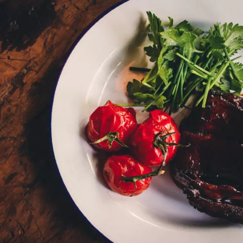 Tomatoes, arugula, and medium-rare stake, well plated